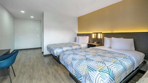 Une chambre d’hôtel avec deux lits, un bureau et une chaise.