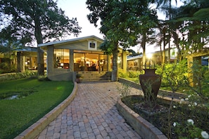 A modern building with a brick pathway leading to a glass entrance.