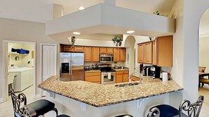 A modern kitchen with granite countertops, stainless steel appliances, and wooden cabinets. - Suffolk Place (Davenport)