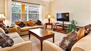 A living room with a sofa set, a coffee table, a TV, and a window with blinds. - Suffolk Place (Davenport)
