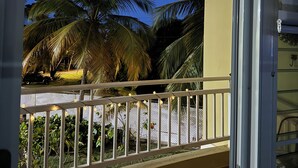 A balcony with a railing, palm trees, and string lights against a twilight sky. - Exclusive Paradise Beach (Medianía Alta)