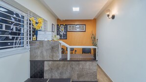 A reception area with a marble counter, framed certificates, and a decorative plant. - Itsy Hotels Sri Mani'S Residency, Coimbatore Airport (Coimbatore)