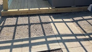 Ett trädäck med en pergola, utomhusmöbler och en bubbelpool.