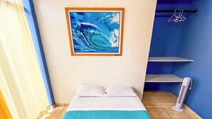 A room with a bed, a painting, a heater, and a curtain. - Hospedaje Sueños DE Chicama, MAS Cerca AL Point, CON UNA Vista Expectacular (LA LIBERTAD)