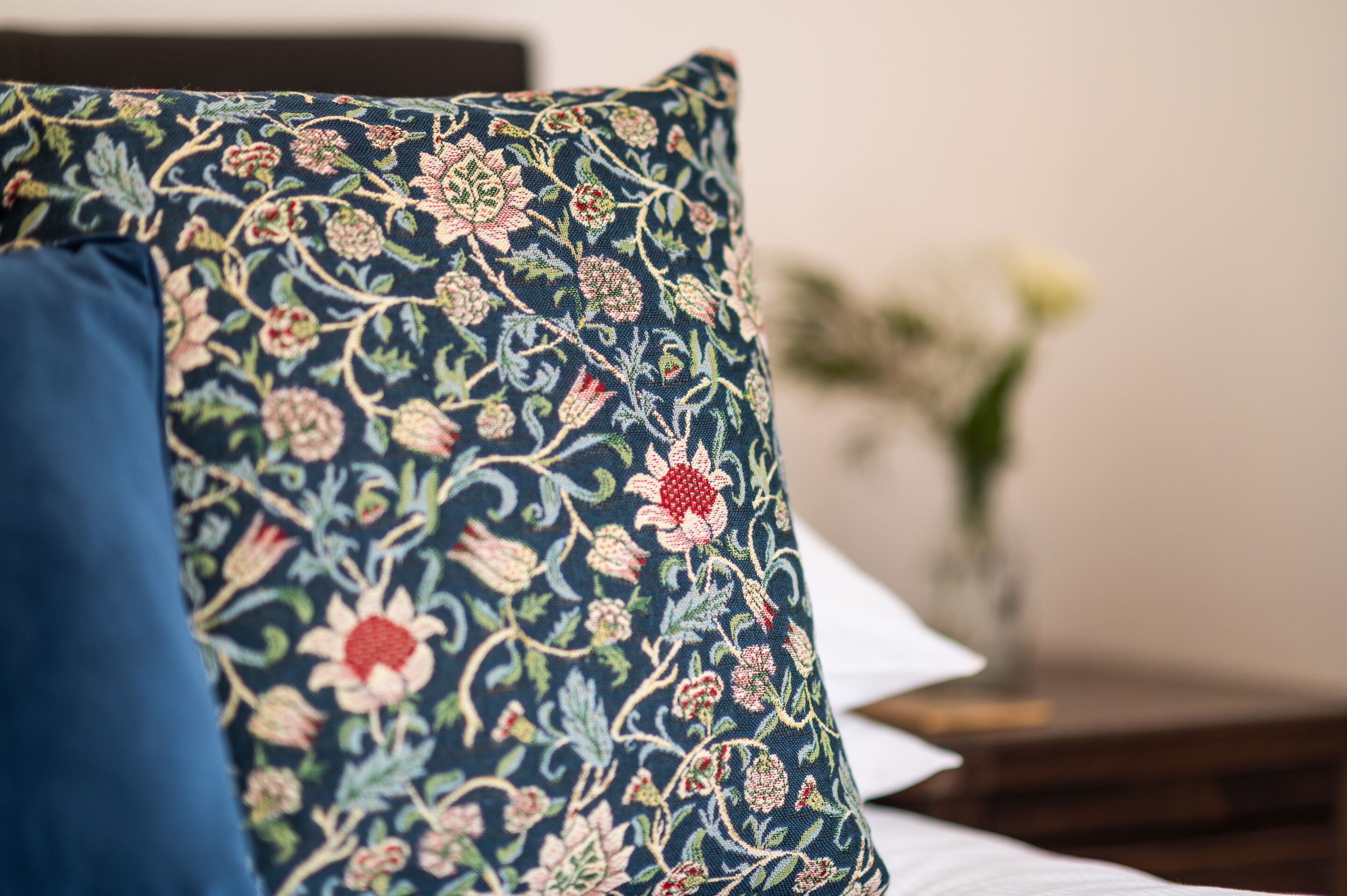 A bed with a floral-patterned pillow and a plain pillow.