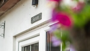 A white building with a sign reading "Sarum" above a window. - Stonehenge Courtyard (Salisbury)