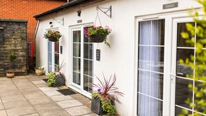 A building with a white exterior, a brick wall on the left, and a sign reading "Sarsen". - Stonehenge Courtyard (Salisbury)