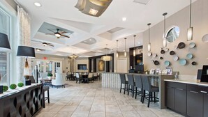 A spacious hotel lobby with a bar area, seating arrangements, and a modern ceiling design.