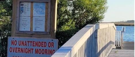 A wooden dock with a sign warning against unattended or overnight mooring.