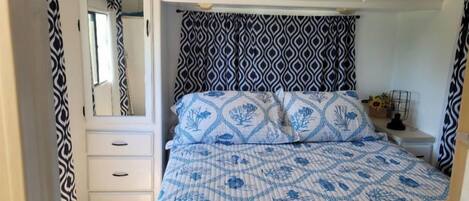 A bedroom with a bed, a dresser, and a nightstand.