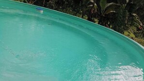 En stor, tom swimmingpool med en blå kant och ett litet blå föremål som flyter på vattnet.