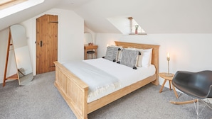 A bedroom with a wooden bed, a small wooden desk, a black chair, and a large mirror. - Host Stay Burnsyde Beach House (Saltburn-by-the-Sea)
