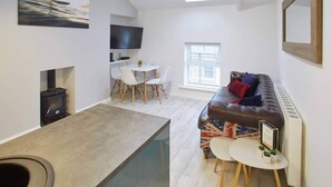 Uma sala de estar moderna com um sofá, uma mesa de centro e uma televisão.