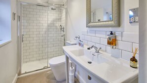 A modern bathroom with a glass-enclosed shower, a white toilet, and a double sink with a mirror above. - Host Stay The Courtyard Retreat (Whitby)
