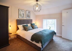 Une chambre à coucher avec un grand lit, une table de chevet, une armoire et une fenêtre donnant sur un beau paysage.