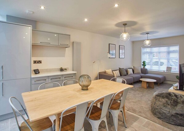 A modern living space with a dining area, kitchen, and seating area. - Host Stay Hoggarths Retreat (Whitby)