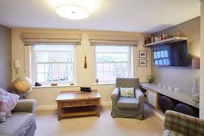Relax in this inviting living room with a comfortable sofa, armchair, and flat-screen TV.