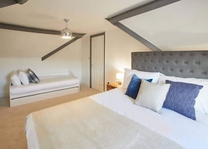 Relax in this stylish bedroom with a large bed and a cozy daybed, perfect for unwinding.