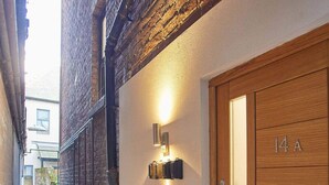 A narrow alleyway with a wooden door marked "14A" and a wall-mounted light fixture. - Host Stay Apartment Two Hudsons Yard House (Whitby)