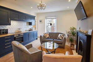 Relax in this stylish living space with a kitchen, comfortable seating area, and flat-screen TV.