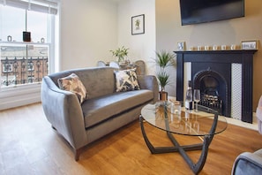 Relax in this stylish living room with a comfortable sofa, coffee table, and fireplace.