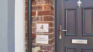 A brick wall with a number '4' sign and a plaque reading 'The Old Sweet Shop'. - Host Stay The Old Sweet Shop (Whitby)
