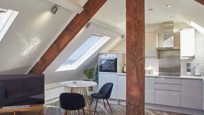 A modern loft apartment with a kitchen, dining area, and living space.