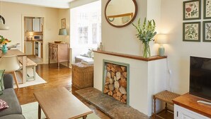 A cozy living room with a fireplace, a television, and a dining area.