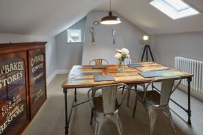 Enjoy meals in this charming dining area with a rustic wooden table, metal chairs, and vintage decor.