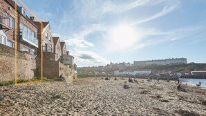 A sandy beach with buildings in the background. - Host Stay No 3 Sandside (Whitby)
