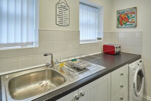 Guests can enjoy a well-equipped kitchen with a stainless steel sink, modern faucet, and a toaster.