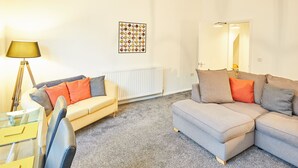 A living room with two sofas, a lamp, a radiator, and a wall art piece. - Host Stay Diamond One (Saltburn-by-the-Sea)
