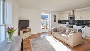 A modern kitchen with white cabinets, a black countertop, and a stainless steel range hood. - Host Stay Abbey Court Apartment (Whitby)