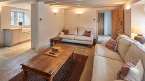 A spacious living area with a sofa, a wooden coffee table, and a kitchen in the background. - Host Stay The Cobbles (Northallerton)