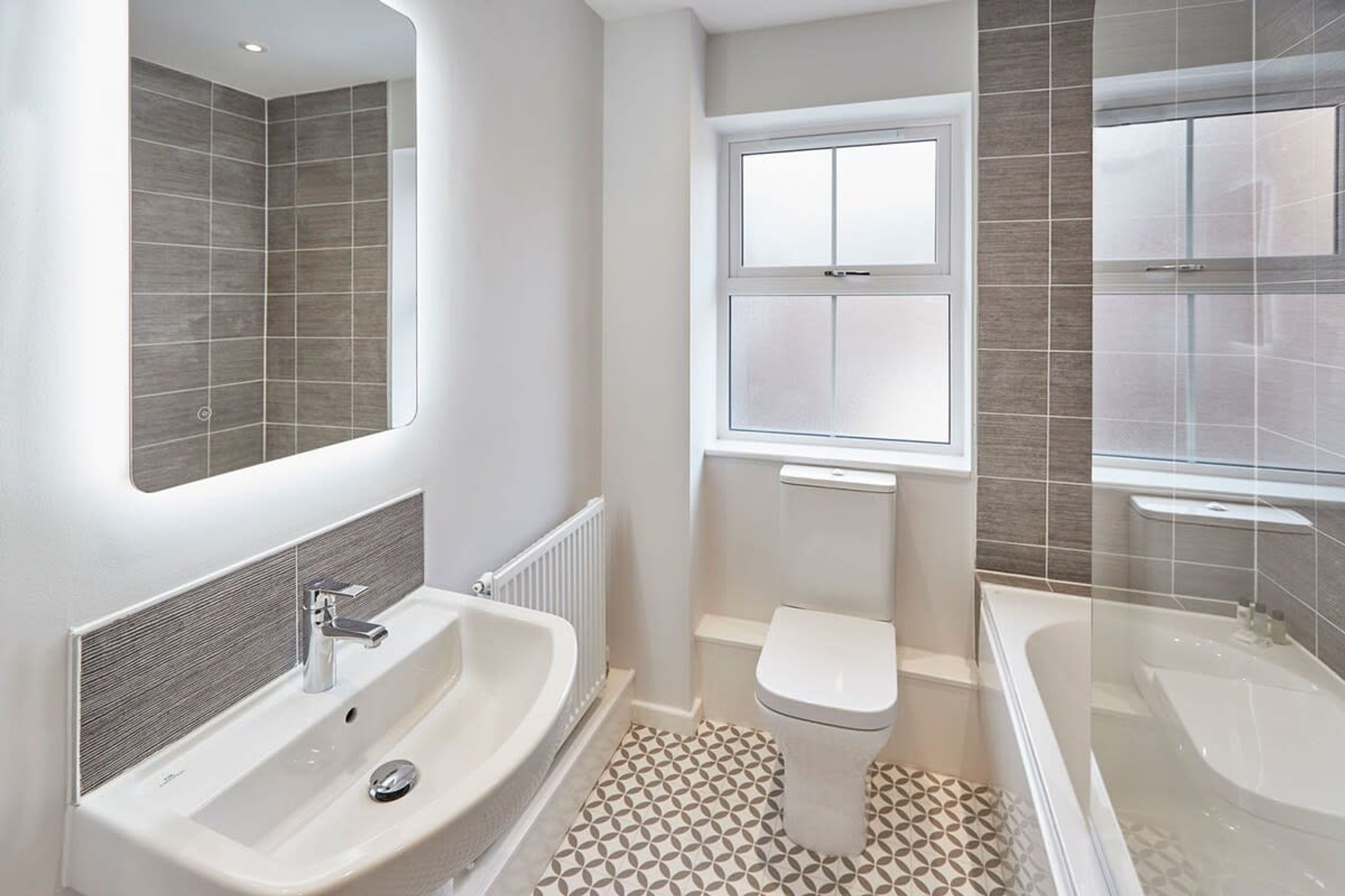 Een moderne badkamer met een groot wastafel, toilet en bad.