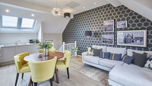Un appartement moderne de style « loft » comprenant un coin repas, un salon et une cuisine.
