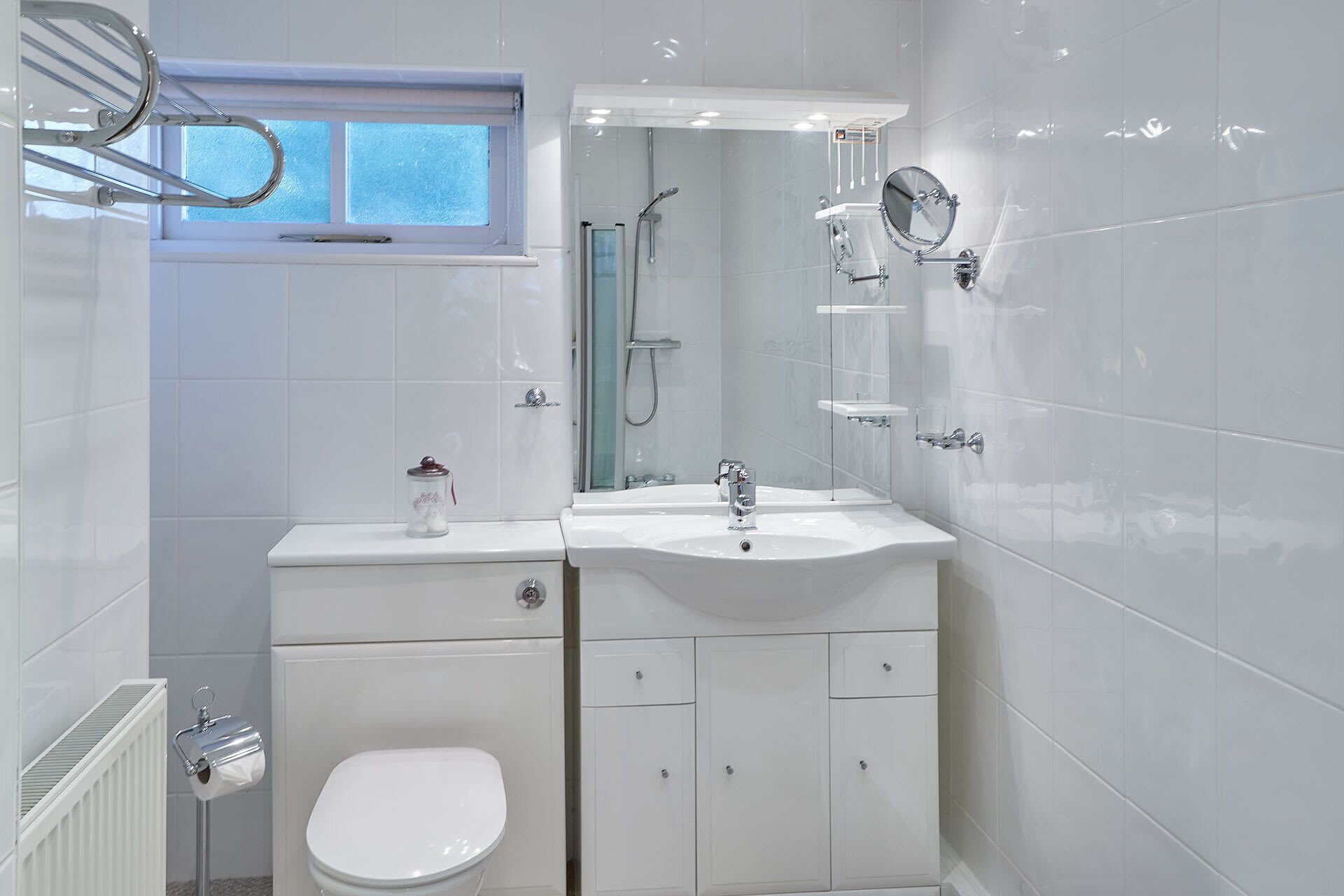 A modern bathroom with a toilet, sink, and shower.