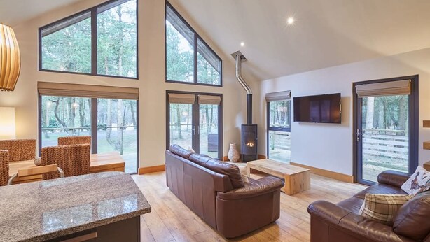 A spacious living room with large windows, a fireplace, and a stone countertop. - Host Stay Simon Howe Lodge (Whitby)