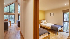 A bedroom with a bed, a bench, and a view of the outdoors. - Host Stay Simon Howe Lodge (Whitby)