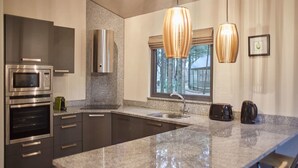 A modern kitchen with granite countertops, stainless steel appliances, and pendant lighting. - Host Stay Simon Howe Lodge (Whitby)