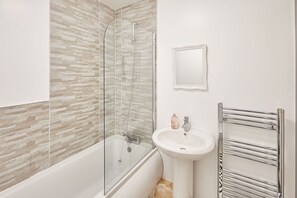 A bathroom with a glass-enclosed shower, a white sink, and a chrome towel rack. - Host Stay Apartment 2 Clarendon (Redcar)