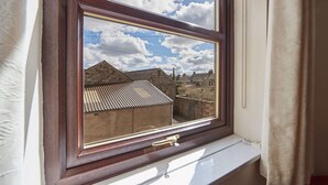 A window with a view of a building with a sloped roof and a brick wall. - Host Stay Wood Street Cottage (Barnard Castle)
