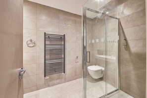 A modern bathroom with a glass-enclosed shower, a wall-mounted towel rack, and a toilet. - Host Stay Berkano The Merchants Quarters (Scarborough)