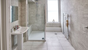 A modern bathroom with a glass-enclosed shower, a white sink, and a bathtub.