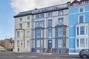 A row of townhouses with bay windows and a front entrance.