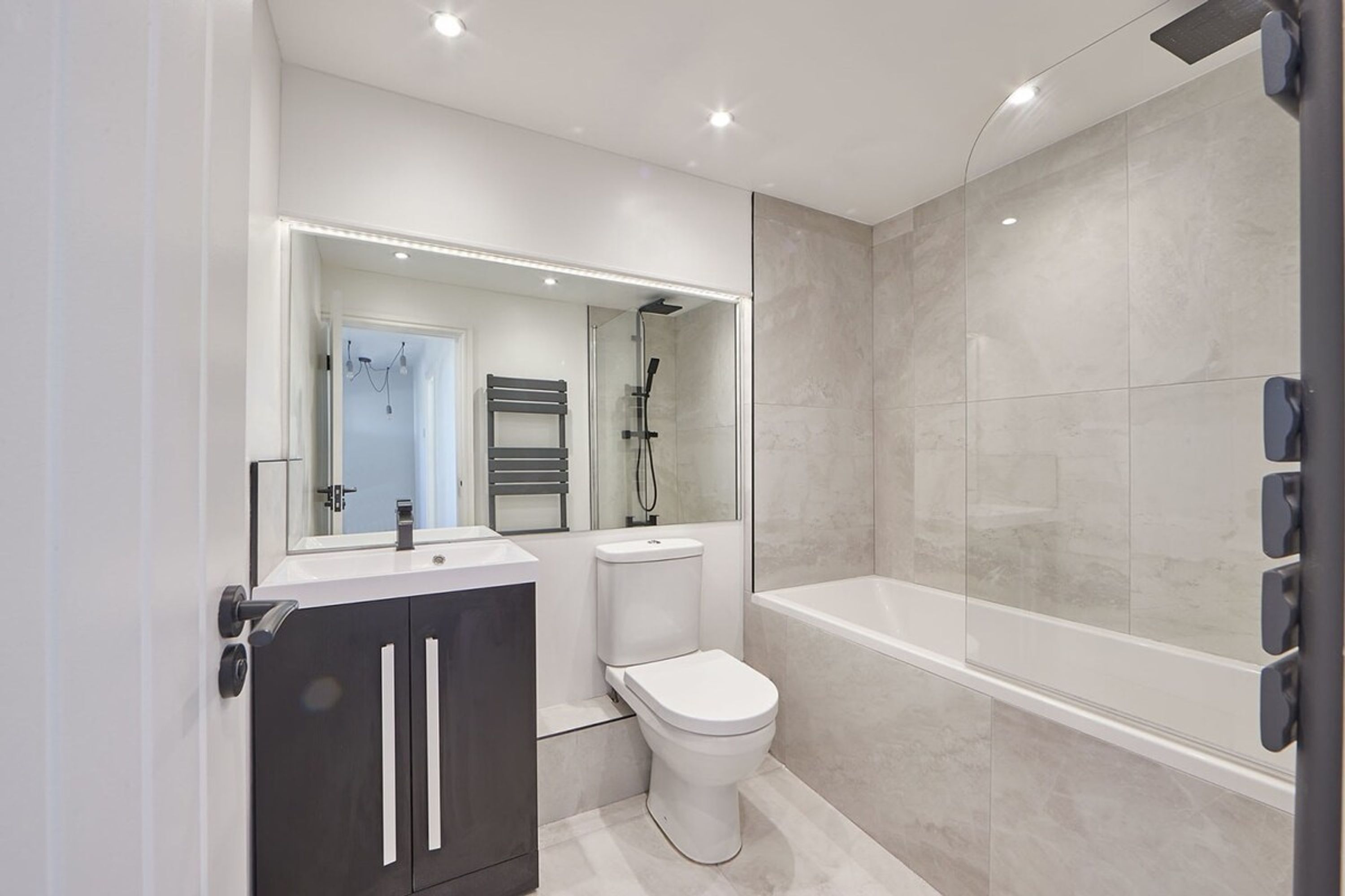 A modern bathroom with a toilet, sink, and bathtub.