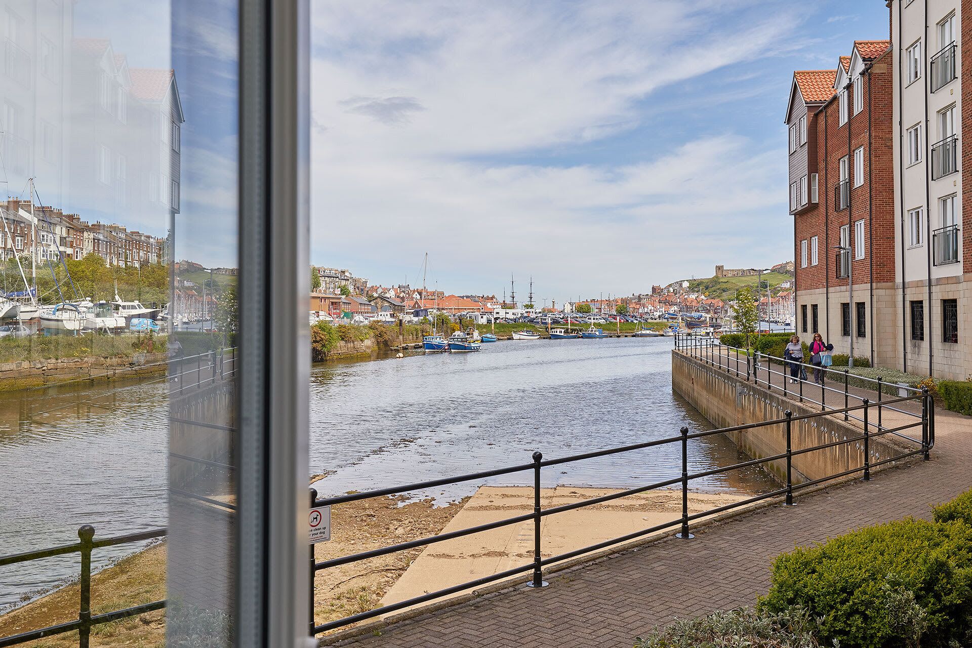 Blick auf einen Fluss mit Kanal, Booten und Gebäuden.
