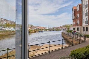 Blick auf einen Fluss mit Kanal, Booten und Gebäuden.