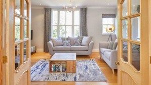 Un salon avec deux canapés, une table basse et une bibliothèque.