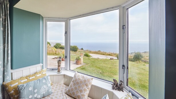 Un rincón acogedor con vistas al mar y un jardín.